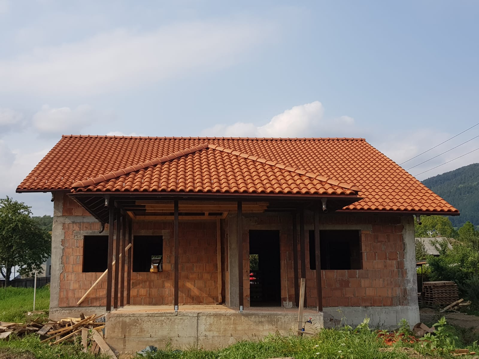 Casă în construcție cu acoperiș roșu